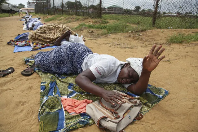 Liberian members of the Women Of Peace Building Network lie on the ground as they are observing two weeks of fasting and praying for God's intervention in eradicating the deadly Ebola virus, Monrovia, Liberia, 04 August 2014. According to statistics from the United Nations, 887 people have died from the Ebola outbreak, making it the worst ever in history. (Photo by Ahmed Jallanzo/EPA)