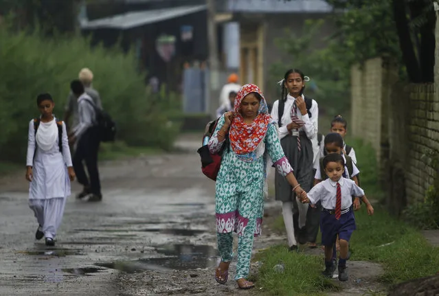 In this Thursday, August 20, 2015 photo, Indian children walk to school, near the India Pakistan international border in Akhnoor sector, 33 kilometers (21 miles) from Jammu, India. (Photo by Channi Anand/AP Photo)
