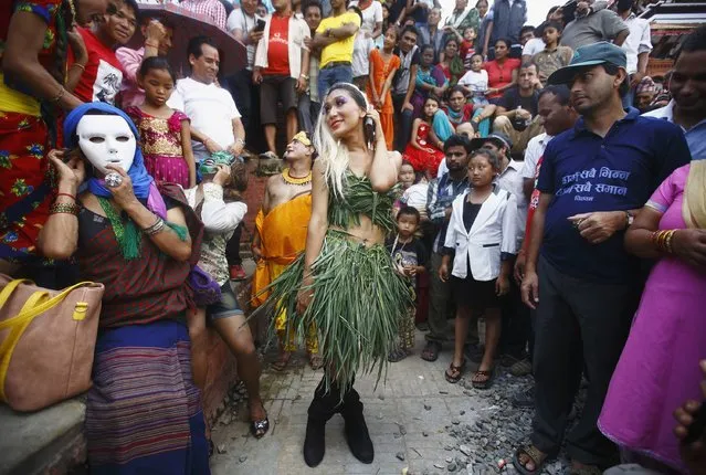 A reveller (C) dances while taking part in a LGBT (lesbian, gay, bisexual, and transgender) pride parade to mark the Gaijatra Festival, also known as the festival of cows, in Kathmandu August 11, 2014. (Photo by Navesh Chitrakar/Reuters)