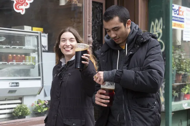 Two patrons of McSorely's Old Ale House in the East Village walking down East 7th Street with their takeout dark ale amid the COVID-19 Coronavirus pandemic in New York on March 17, 2020. (Photo by Taidgh Barron/The New York Post)