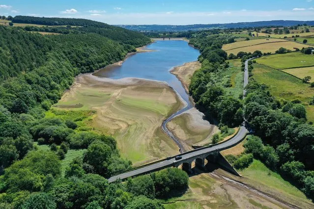 An aerial view of the drying out bed and receded water levels at Lindley Wood Reservoir on July 13, 2022 in Otley, England. A spokesman for Yorkshire Water, the regional water utility, noted that Lindley Wood is a "compensation reservoir" that takes excess water from nearby reservoirs that supply customers. In a heatwave like England is currently experiencing, residential demand for water is high, and water would not be sent to overflow reservoirs like Lindley Wood. (Photo by Christopher Furlong/Getty Images)