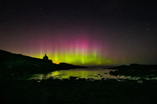 The aurora borealis, or the northern lights occur over the Bathing House in Howick, England, Monday November 9, 2015. The northern lights are the result of collisions between gaseous particles in the Earth's atmosphere with charged particles released from the sun. (Photo by Owen Humphreys/PA Wire via AP Photo)