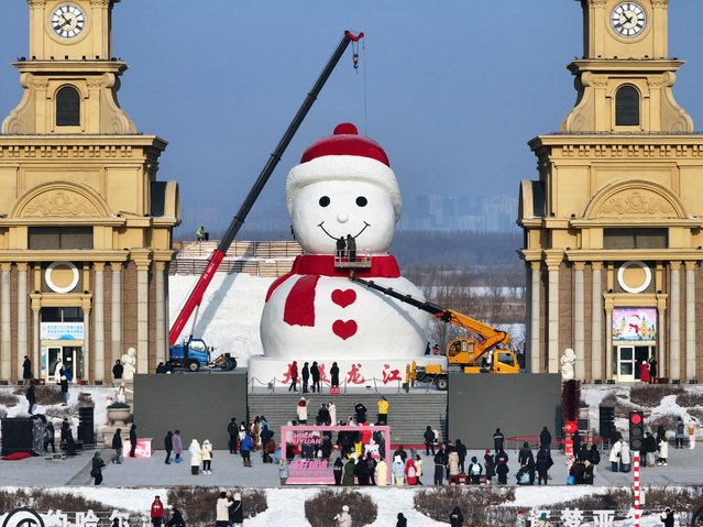 The giant snowman wearing a red scarf stands at Harbin Music Park on December 17, 2024 in Harbin, Heilongjiang Province of China. An old friend to Harbin, a giant snowman kept its annual rendezvous with local residents to make its first appearance of this winter at a park in Harbin City, Heilongjiang Province. (Photo by VCG/VCG via Getty Images)