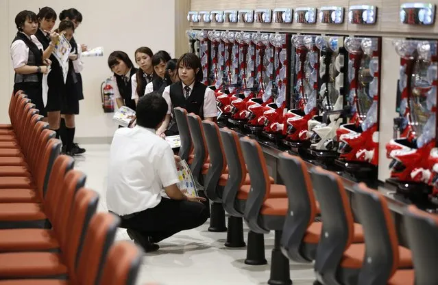 Dynam employees receive customer-care training ahead of the grand opening of the company's pachinko parlour in Fukaya, north of Tokyo July 29, 2014. (Photo by Issei Kato/Reuters)