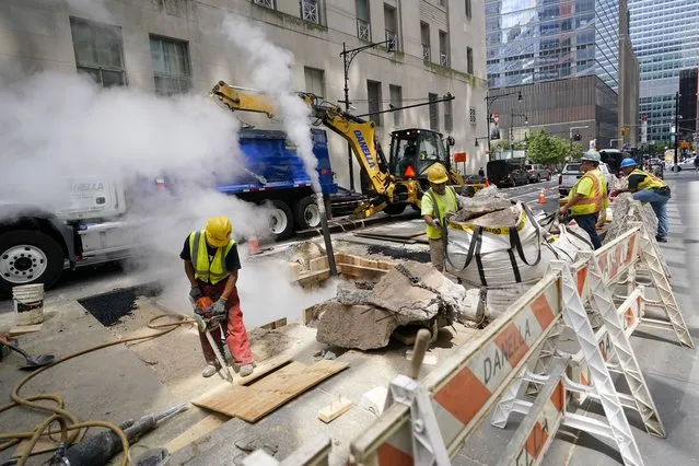 A construction crew works on fixing a ruptured steam pipe in lower Manhattan, Wednesday, August 17, 2022 in New York. (Photo by Mary Altaffer/AP Photo)