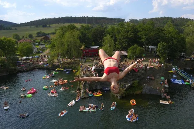 A diver jumps into water during a high diving competition near the village of Hrimezdice, Czech Republic, Friday, August 5, 2022. (Photo by Petr David Josek/AP Photo)