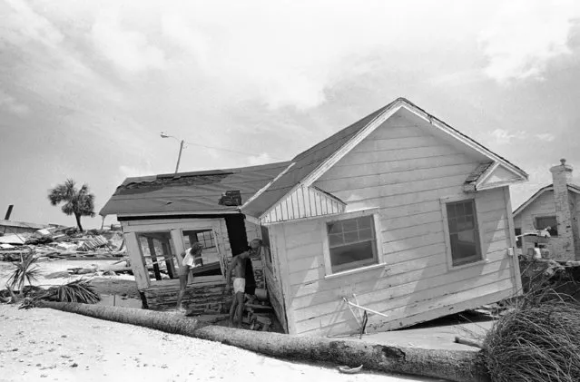 Residents of Indian Rocks Beach, Fla., look inside a damaged house on September 3, 1985. They were allowed to return to their house to inspect the damage. (Photo by Raul de Molina/AP Photo)