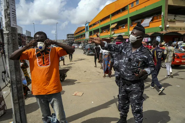 A security forces officer tells a man to wear a face mask as the spread of the coronavirus disease (COVID-19) continues, in Abidjan, Ivory Coast on April 22, 2020. (Photo by Luc Gnagos/Reuters)