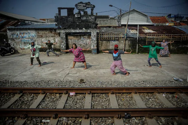 People practice social distancing while stretching along rail tracks amid the coronavirus disease (COVID-19) outbreak in Bandung, West Java Province, Indonesia, April 15, 2020. (Photo by Raisan Al Farisi/Antara Foto via Reuters)