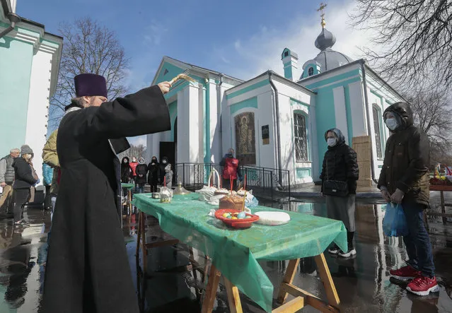 Russian Orthodox Church priest blesses food on the eve of Orthodox Easter Sunday in Moscow, Russia, 18 April 2020. Patriarch of Moscow and All Russia called believers to watch Easter service on TV and not to visit the churches in order to avoid coronavirus infection spreading. (Photo by Sergei Chirikov/EPA/EFE)