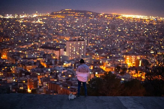 A man looks over the city as he walks his dog on March 17, 2020 in Barcelona, Spain. As part of the measures against the virus expansion the Government has declared a 15-day state of emergency. The Government of Spain has strengthened up its quarantine rules, shutting all commercial activities except for pharmacies, food shops, gas stations, tobacco stores and news kiosks in a bid to stop the spread of the novel coronavirus, as well as transport. Spaniards must stay home except to go to work but working from home is recommended, going to buy basic things as food or pharmacy products is allowed but it must be done individually. The number of people confirmed to be infected with the coronavirus (COVID-19) in Spain has increased to at least 11,178, with the latest death toll reaching 491 according to the country’s Health Ministry. (Photo by David Ramos/Getty Images)