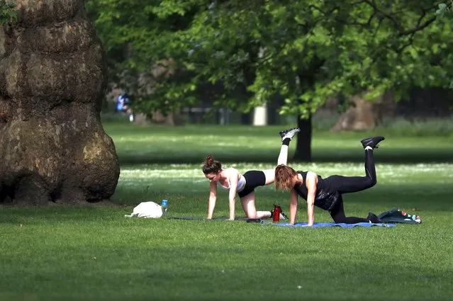 People exercise in St James Park in London, Sunday, May 10, 2020 during the nation-wide coronavirus lockdown. (Photo by Frank Augstein/AP Photo)