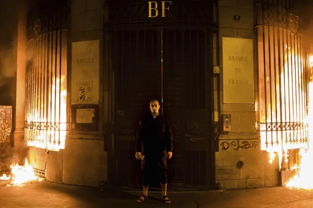Russian artist Petr Pavlensky poses in front of a Banque de France building after setting fire to the window gates as part of a performance in Paris, Monday, October 16, 2017. Pavlensky, known for macabre, politically charged actions, was being detained by police. (Photo by Capucine Henry/AP Photo)