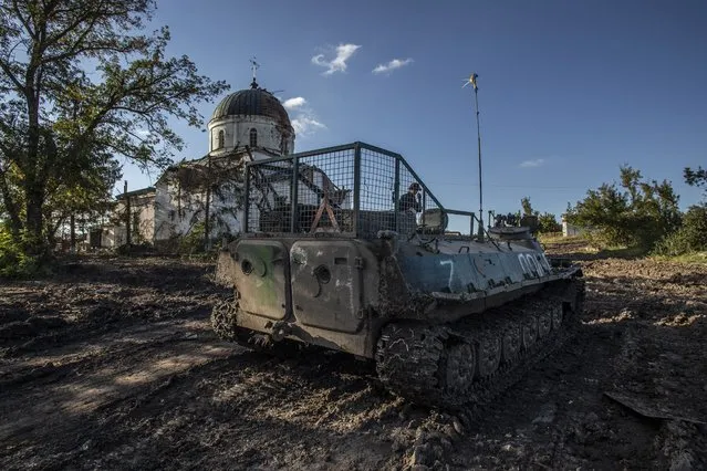 A Ukrainian soldier inspects an abandoned Russian tank in the recently retaken area close to Izium, Ukraine, Wednesday, September 21, 2022. (Photo by Oleksandr Ratushniak/AP Photo)