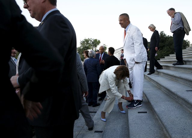 U.S. House Minority Leader Nancy Pelosi (D-CA) (center L) ties a shoelace for Representative Donald Payne Jr. (D-NJ) (center R, standing), who is recovering from a foot injury, after a rally in support of the nuclear deal with Iran on the East Front steps of the U.S. Capitol in Washington September 8, 2015. President Barack Obama on Tuesday secured 41 votes in the U.S. Senate for the international nuclear deal with Iran, just enough to block a final vote on a measure of disapproval. (Photo by Jonathan Ernst/Reuters)