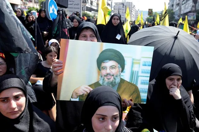 A Shi'ite Muslim woman carries a picture of Lebanon's Hezbollah leader Sayyed Hassan Nasrallah during a religious procession to mark Ashura in Beirut's suburbs, Lebanon on August 9, 2022. (Photo by Aziz Taher/Reuters)