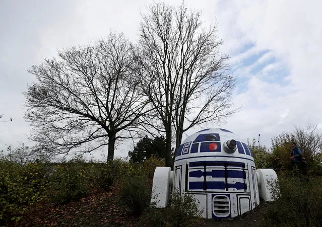 A man stands near an air vent of a bomb shelter painted by an unknown street artist as Star Wars robot R2-D2 in a park in Prague, Czech Republic October 28, 2017. (Photo by David W. Cerny/Reuters)