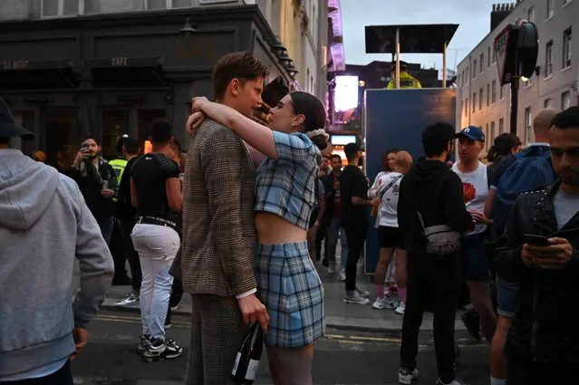 Revellers embraces as in the street outside bars in the Soho area of London on July 4, 2020, as restrictions are further eased during the novel coronavirus COVID-19 pandemic. Pubs in England reopen on Saturday for the first time since late March, bringing cheer to drinkers and the industry but fears of public disorder and fresh coronavirus cases. (Photo by Justin Tallis/AFP Photo)