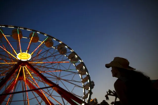 A woman looks up at a ferris wheel at the Iowa State Fair in Des Moines, Iowa, United States, August 15, 2015. (Photo by Jim Young/Reuters)