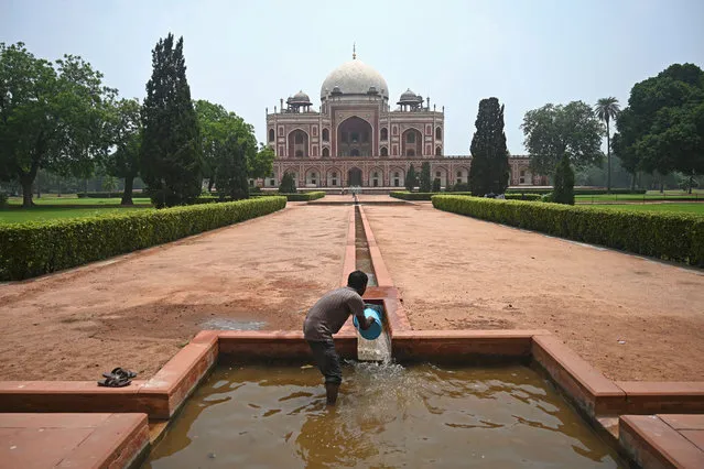 A worker cleans an artifical water channel at the 16th century Mughal monument Humayun's Tomb, after it was reopened for visitors which was closed since mid-March as part of measures to try and combat the spread of the COVID-19 coronavirus, in New Delhi on July 6, 2020. India announced on July 6 that it had logged nearly 700,000 coronavirus cases, taking it past Russia to become the world's third-hardest-hit nation in the global pandemic. (Photo by Sajjad Hussain/AFP Photo)