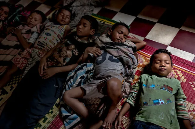 Five brothers, ranging in age from 5 to 12,  sleep together on the floor at At the Krousa Thmey Center, a temporary orphanage.  The shelter serves as a safe house for children who have been abandoned and found wandering the streets. Space is limited, so the children cannot stay for long, but they are offered temporary refuge from the influences of the city streets. Phnom Penh, Cambodia. (Photo by Renée C. Byer/Living on a Dollar a Day)