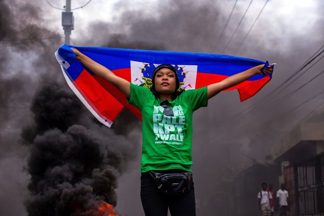 A women holds a flag during a protest against insecurity and violence in Port-au-Prince, Haiti, 26 March 2025. Kenyan officer of the Multinational Security Support Mission in Haiti who was initially reported missing after an attack by armed gangs in Savien, in the Artibonite department (center of the country), has died, the Presidential Transitional Council (CPT) confirmed. (Photo by Mentor David Lorens/EPA)