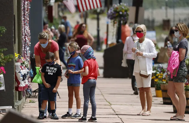Visitors wear face coverings while walking around Monday, July 27, 2020, in the Mountain tourist town of Georgetown, Colo. (Photo by David Zalubowski/AP Photo)