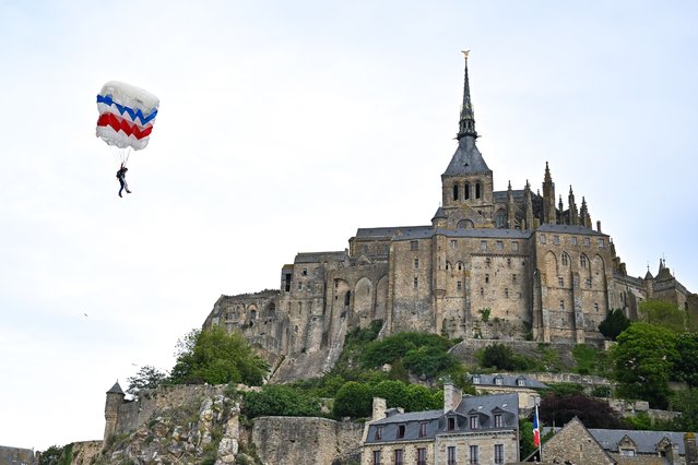 French world champion in parachuting Adeline Delecroix, parachutes in front of of the Mont Saint-Michel, in western France, as part of a precision jump by multiple parachutists to mark the 80th anniversary of the end of the Second World War, on May 8, 2025. (Photo by Lou Benoist/AFP Photo)