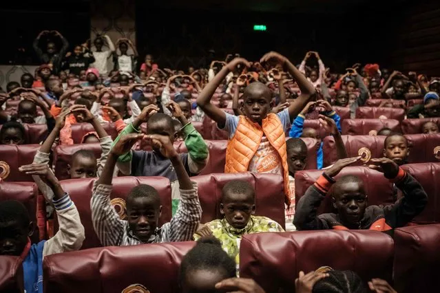 About 500 invited children from the Kibera slum learn posing as they watch “The Nutcracker”, a ballet primarily performed during the Christmas period, by the Dance Centre Kenya (DCK) with the Nairobi Philharmonic Orchestra at the National Theatre in Nairobi on December 3, 2022. (Photo by Yasuyoshi Chiba/AFP Photo)