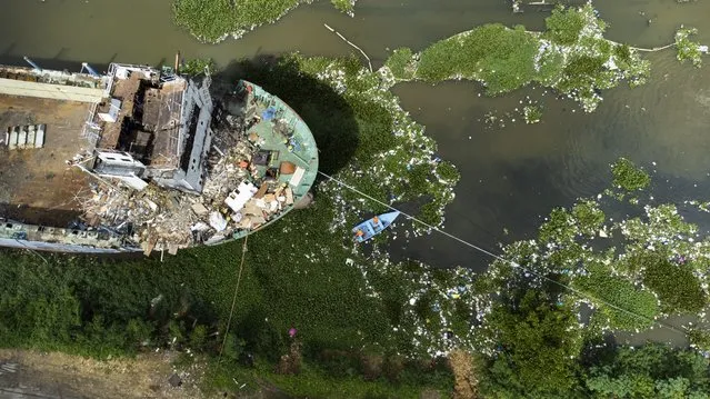 A view of the Bel Divina Pastora ship on the bed of the Ozama river, in Santo Domingo, Dominican R., on 15 November 2022. Eight metal colossi lie in the bed of the Ozama River, some for three decades, polluting it and preventing the navigability of what was once the pluvial artery of the Dominican capital, on whose surface work is already being done to scrap the rusty ship Bel Divina Pastora. The dismantling of the ship, 92 meters long, is only the beginning of the work to rehabilitate the river, sick of receiving garbage and harboring polluting waste, such as the wrecks that once transported sugar and cement. (Photo by Orlando Barría/EPA/EFE)