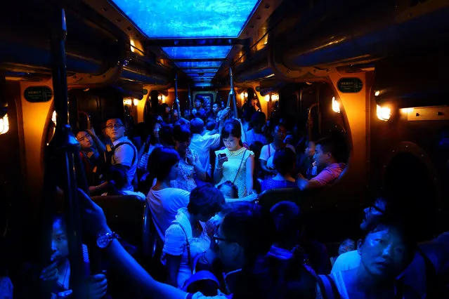 “A node glows in the dark...” In the last 10 years, mobile data, smart phones and social networks have forever changed our existence. Although this woman stood at the center of a jam packed train, but the warm glow from her phone tells the strangers around her that she's not really here. Photo location: Hong Kong. (Photo and caption by Brian Yen/National Geographic Photo Contest)