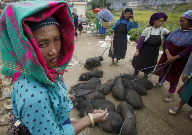 Vietnamese women of Hmong ethnicity sell piglets at a weekend market in Dong Van district, north of Hanoi, Vietnam September 20, 2015. (Photo by Reuters/Kham)