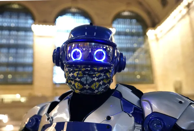 MTA-North Railroad's mascot, Metro-Man hands out facemasks to commuters as they arrive at Grand Central Terminal on September 2, 2020 in New York. Facemasks are required to ride the MTA's Metro-North Railroad, which serves New York and parts of New York state and Connecticut, as the face coverings are a critical tool in the fight against covid-19. (Photo by Timothy A. Clary/AFP Photo)