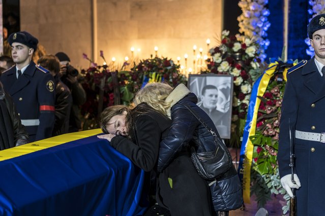 A woman mourns over the casket of Yevhen Yenin, the first deputy minister for internal affairs, during a memorial service for Denys Monastyrsky, Ukraine’s minister for internal affairs, and the eight other people who died when the helicopter they were riding in crashed earlier this week in a nearby suburb, in Kyiv, Ukraine on Saturday, January 21, 2023. (Photo by Brendan Hoffman/The New York Times)