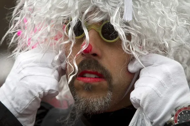 A clown adjusts his wig as he gets ready to participate in the Macy's Thanksgiving Day Parade in New York, November 27, 2014. (Photo by Carlo Allegri/Reuters)