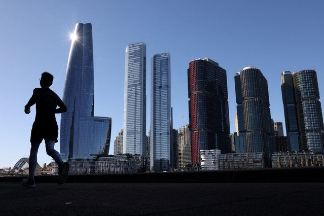 A man jogs past the Barangaroo skyline in Sydney, Australia, on July 9, 2025. (Photo by Hollie Adams/Reuters)