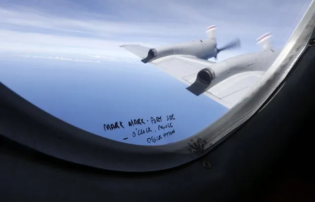 Handwritten notes on how a crew member should report the sighting of debris in the southern Indian Ocean are pictured on a window aboard a Royal New Zealand Air Force P-3K2 Orion aircraft searching for missing Malaysian Airlines flight MH370, in this March 22, 2014 file photo. (Photo by Jason Reed/Reuters)
