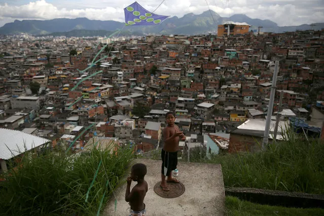 A boy flies a kite at the Complexo do Alemao slum in Rio de Janeiro, Brazil on February 24, 2018. (Photo by Pilar Olivares/Reuters)