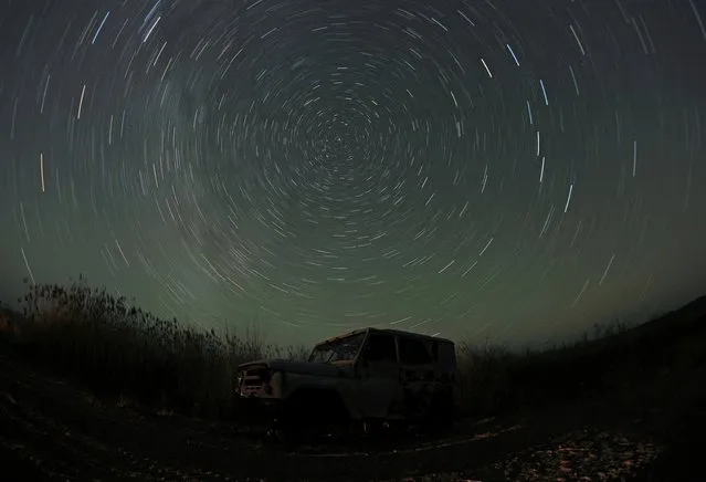 A long exposure picture shows stars above the abandoned car on a bank of the Ili River in Almaty region, Kazakhstan, February 5, 2022. (Photo by Pavel Mikheyev/Reuters)
