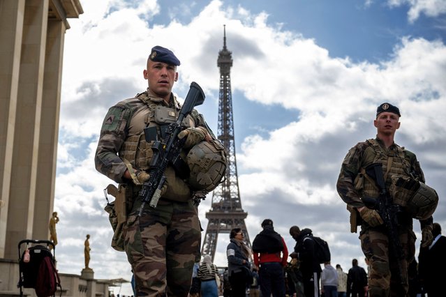 French soldiers from the Operation Sentinel patrol on the Trocadero Esplanade near the Eiffel Tower in Paris, on April 15, 2024. French President Emmanuel Macron has hinted in an interview at alternative solutions in the event of a major terrorist threat to the opening ceremony of the Paris 2024 Olympic Games. (Photo by Julien de Rosa/AFP Photo)