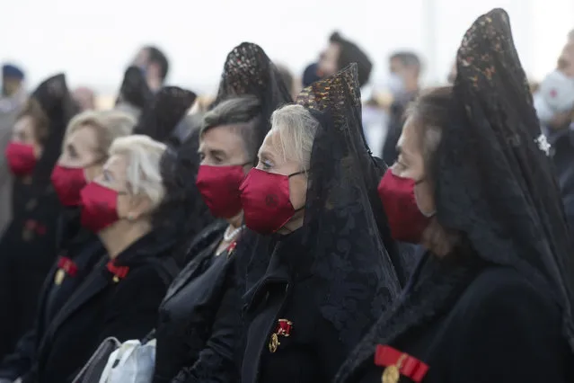 Women dressed in traditional mantillas and wearing face masks to protect against the spread of coronavirus, take part in an open air mass to celebrate Madrid's patron saint La Almudena virgin in Madrid, Spain, Monday, November 9, 2020. Some Spanish regions are tightening their restrictions on movement, as the national government waits to see whether its measures to slow the spread of COVID-19 are working before taking further steps. (Photo by Paul White/AP Photo)