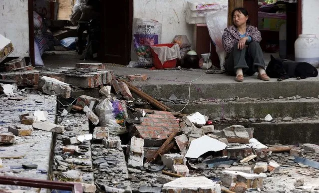 A woman looks over at her destroyed house in Gucheng village in China's Sichuan province, on April 21, 2013. (Photo by Associated Press)