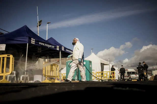 A worker sanitises the area used by migrants at the Arguineguin port, on the southwestern coast of the Gran Canaria island, Spain on Monday November 30, 2020. Spain has dismantled most of the temporary camp for migrant processing that for over three months became known as the “dock of shame” for holding in unfit conditions thousands of Africans arriving lately in the Canary Islands. (Photo by Javier Fergo/AP Photo)