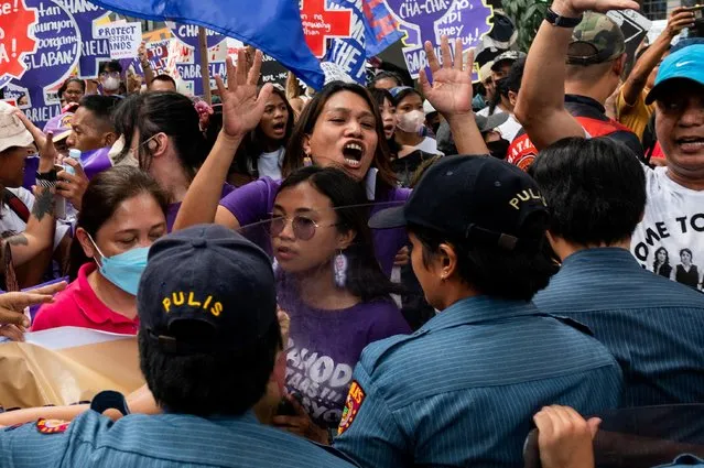 Filipino women and activists attempt to get past a police blockade during a protest on Women's Day, in Manila, Philippines on March 8, 2023. (Photo by Lisa Marie David/Reuters)