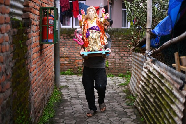 An artist carries a clay statue of Lord Vishwakarma to the market for sale before the Vishwakarma Puja festival in Nepal, Kathmandu on September 16, 2025. The festival, celebrated on September 17 this year, honors Lord Vishwakarma, regarded as the divine engineer and craftsman, and involves prayers for creativity, prosperity, and protection of tools and workplaces. (Photo by Safal Prakash Shrestha/ZUMA Press Wire/Rex Features/Shutterstock)