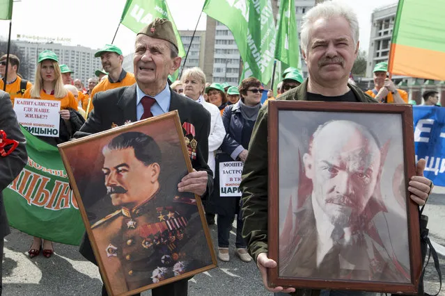 Two elderly men carry portraits of Soviet founder Vladimir Lenin, right, and former Soviet leader Josef Stalin during a Communist rally to mark May Day in Moscow, Russia, May 1, 2018. Workers and activists marked May Day on Tuesday with rallies to demand their government address labor issues. (Photo by Alexander Zemlianichenko/AP Photo)