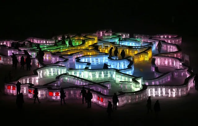 People visit a maze which was built by ice bricks and illuminated by coloured lights during a trial operation ahead of the 31st Harbin International Ice and Snow Festival in the northern city of Harbin, Heilongjiang province, January 4, 2015. (Photo by Kim Kyung-Hoon/Reuters)