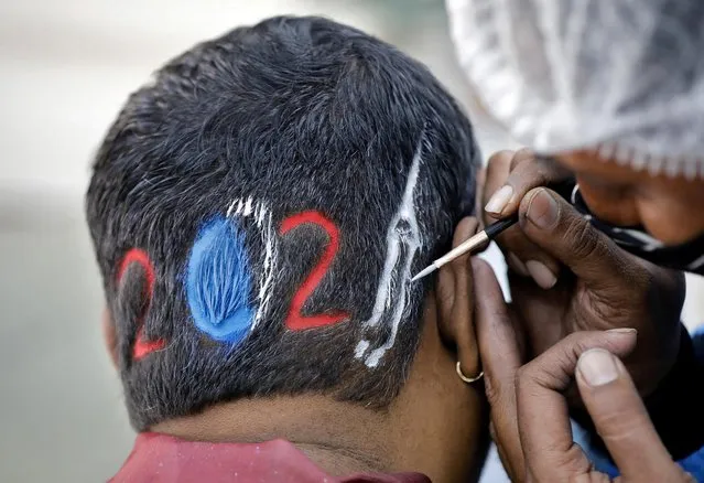 A hairdresser styles a “2021” shave for a client to welcome the New Year at a barbershop in Ahmedabad, India, December 31, 2020. (Photo by Amit Dave/Reuters)