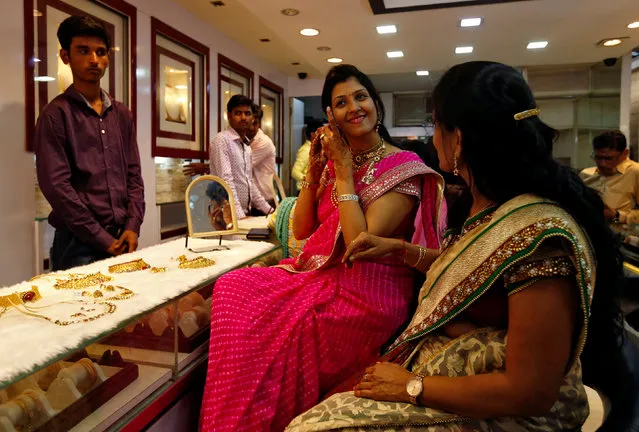 A woman tries a gold earring at a jewellery showroom during Dhanteras, a Hindu festival associated with Lakshmi, the goddess of wealth, in Mumbai, India October 28, 2016. (Photo by Danish Siddiqui/Reuters)