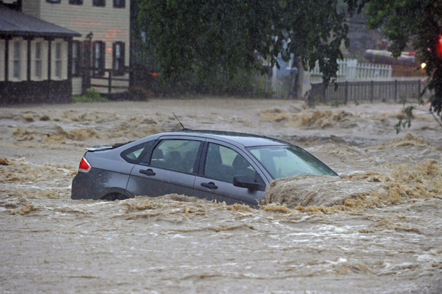 A parked car is flooded in a lot near Main Street and Ellicott Mills Road as a heavy storm caused flash floods in Ellicott City, Md., Sunday, May 27, 2018. Roaring flash floods struck the Maryland city Sunday that had been wracked by similar devastation two years ago, its main street turned into a raging river that reached the first floor of some buildings and swept away parked cars, authorities and witnesses say. (Photo by Kenneth K. Lam/The Baltimore Sun via AP Photo)